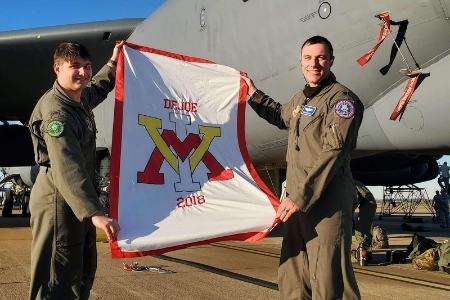 1st Lt Tyler DeJoe '18 with Lt Col B.D. Harrison '02 holding VMI flag after Lt DeJoe’s B-52 checkride